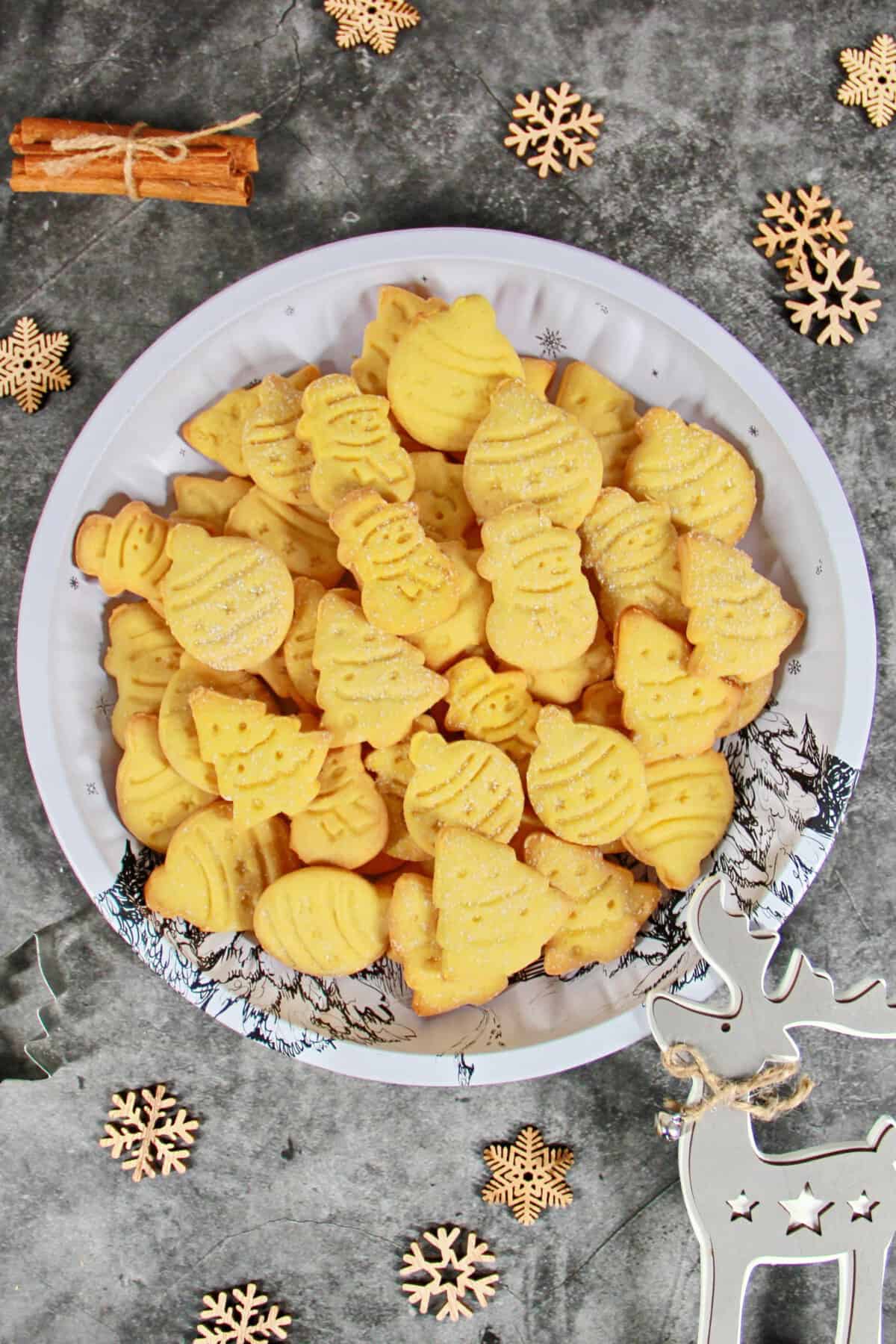 Christmas cut-out cookies arranged on a light-colored plate.