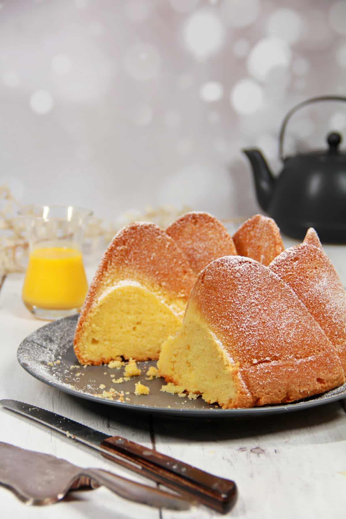 A sliced egg liqueur cake on a dark serving platter.