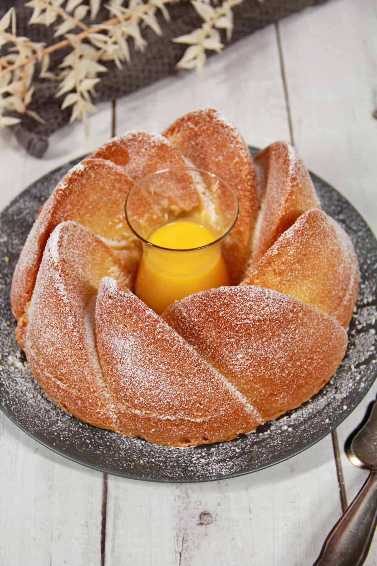 An eggnog cake on a round, dark serving platter.