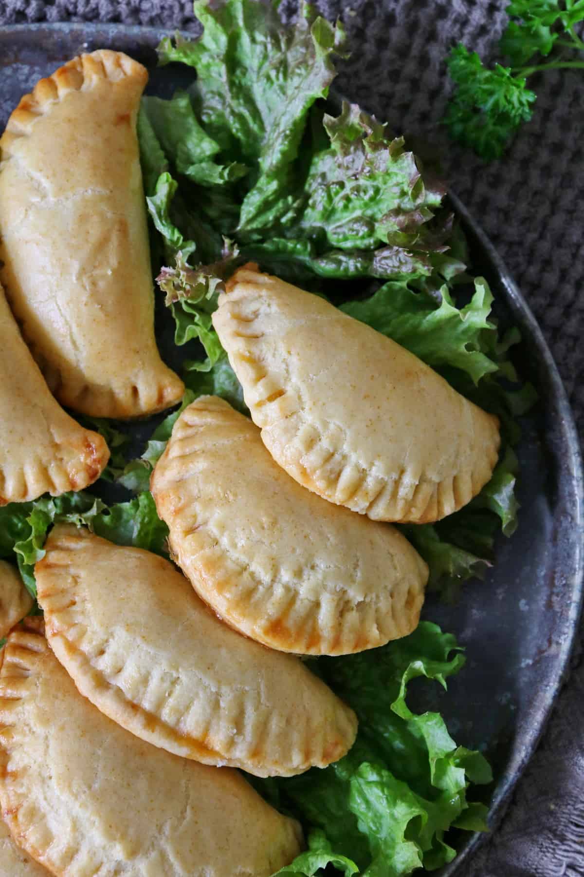 A close-up shot of a plate of freshly baked ground beef empanadas.
