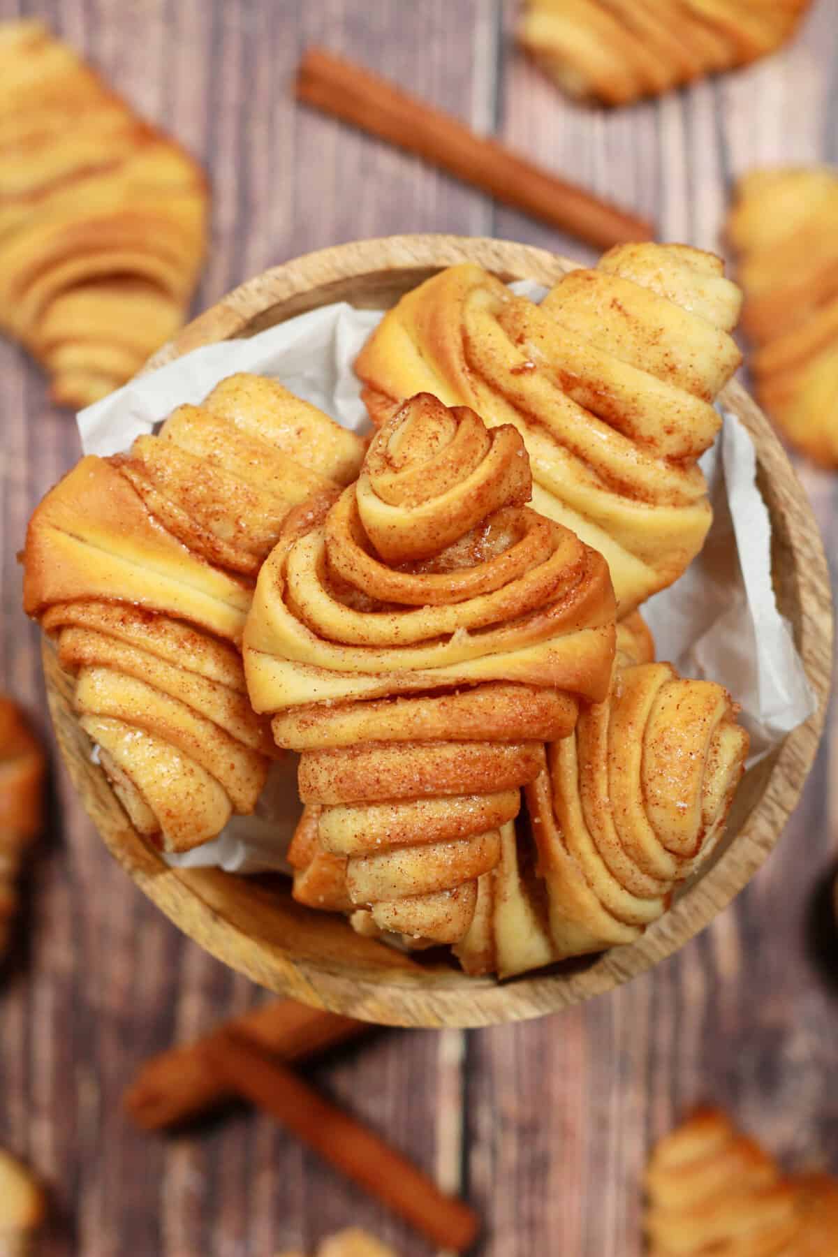 A round wooden bowl filled with mini Franzbrötchen.