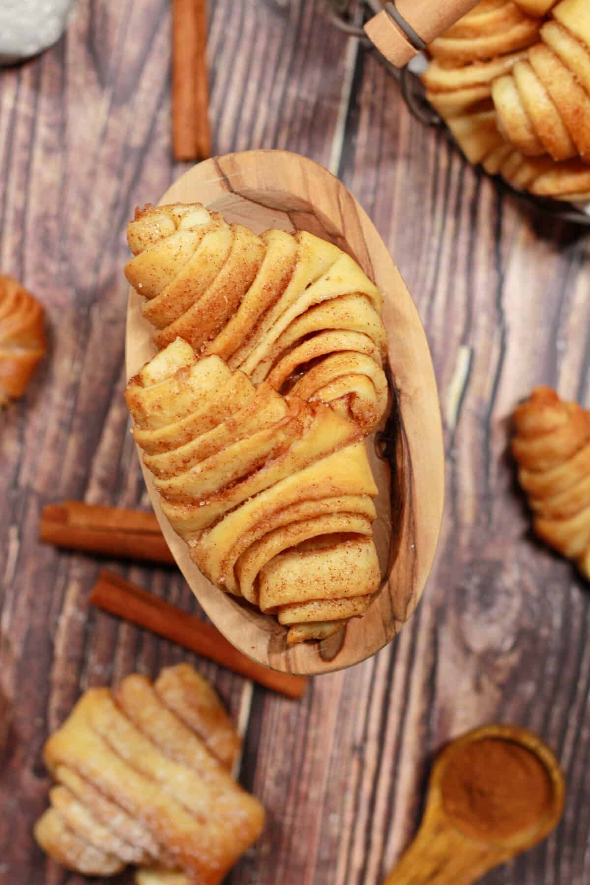 A small oval wooden bowl filled with mini Franzbrötchen.