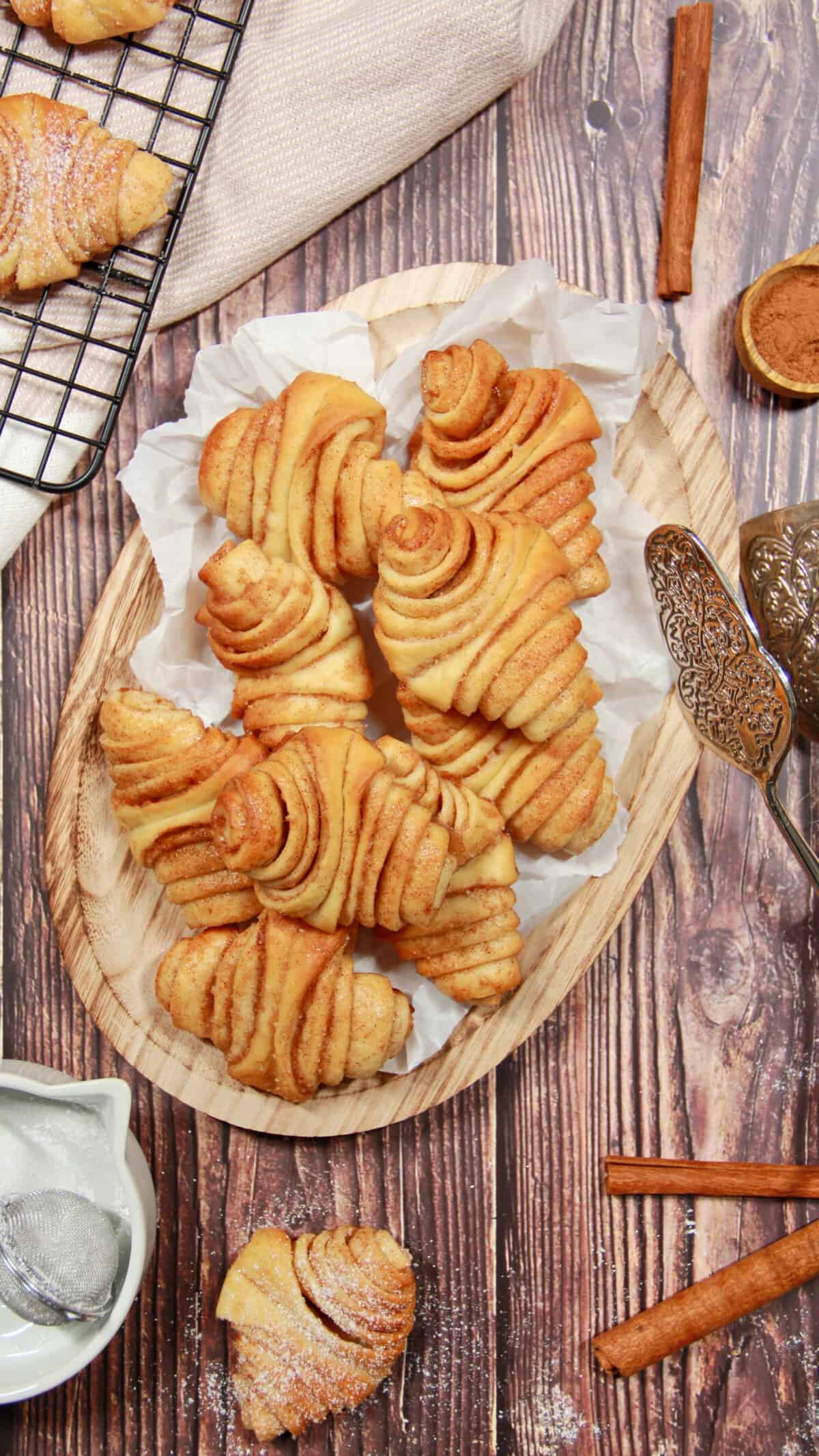 Mini Franzbrötchen arranged on an oval wooden serving tray.