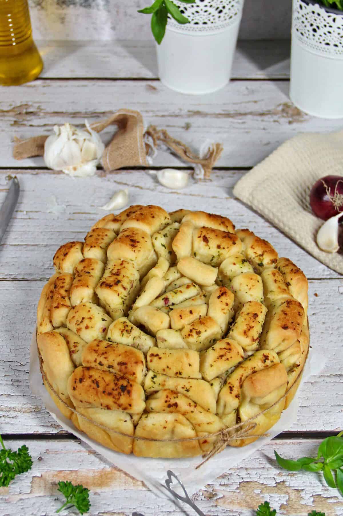 A round loaf of pull-apart herb bread.