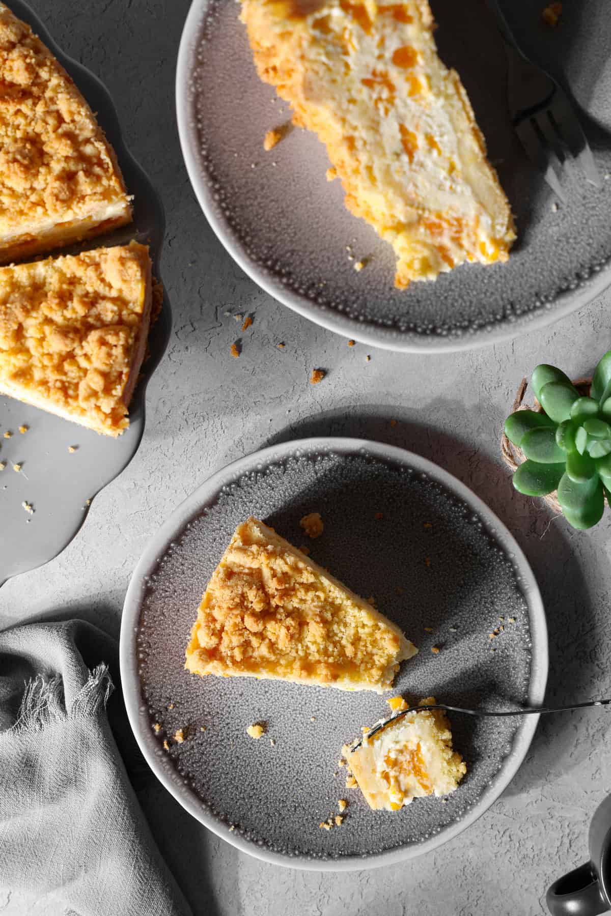 Several slices of mandarin sour cream crumb cake on plates.