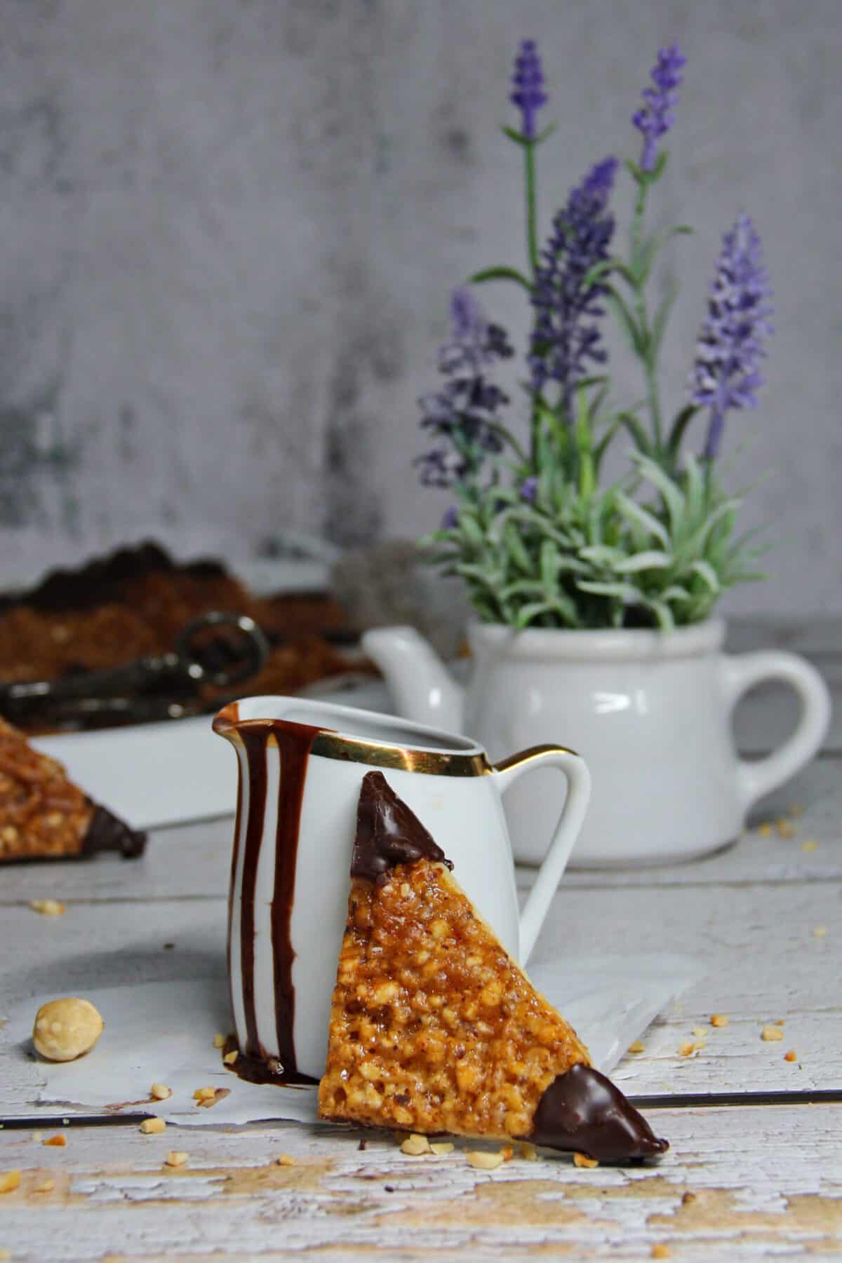A German nut bar (Nussecke) leaning against a mug.