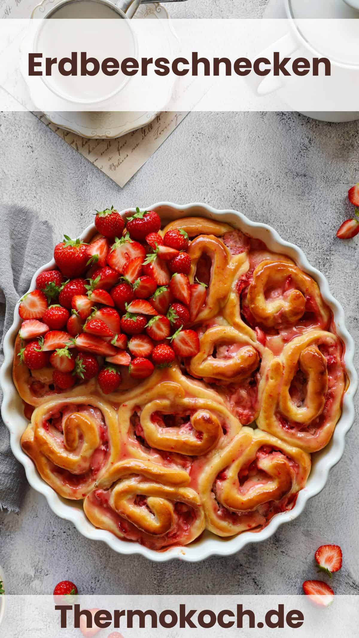 A round, white baking dish filled with strawberry rolls and fresh strawberries.